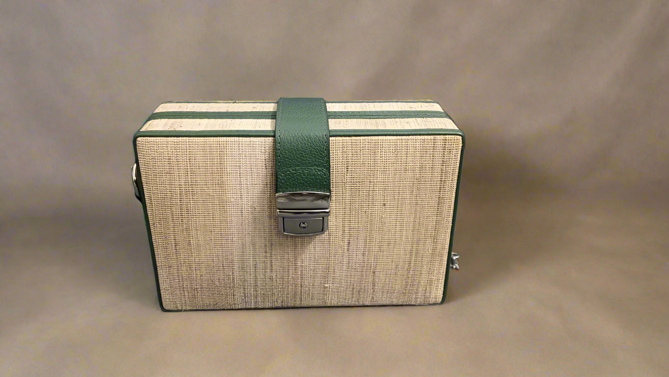 Wooden box with a green strap on a gray background

